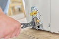 Installing an air conditioner in an apartment office, close-up of an technician hands