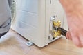 Installing an air conditioner in an apartment office, close-up of an technician hands