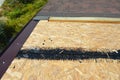 Installing asphalt roof shingles on the underlayment of the house construction repairing and waterproofing the rooftop corner