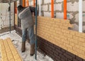 Installing brick siding on the wall of the house