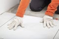 Installing ceramic tiles on the floor. A worker installs ceramic tiles at home