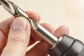 Installing a drill bit in a drill, hands take a drill and install it in a cordless drill chuck Royalty Free Stock Photo