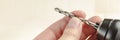 Installing a drill bit in a drill, hands take a drill and install it in a cordless drill chuck Royalty Free Stock Photo