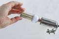 Installing an energy-efficient LED lamp in ceiling light. Royalty Free Stock Photo