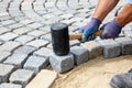 Installing granite cobblestone pavers with a rubber mallet for a durable walkway Royalty Free Stock Photo