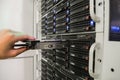 Installing a hard disk in the server room of the data center. Replacing the hard drive close-up.