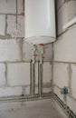 Installing and hide in wall water pipes in the house bath room with electric boiler. Groove or trench cut for water pipes in the