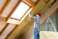 Installing insulation in attic for home renovation. Ecological home concept Royalty Free Stock Photo