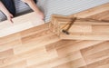 Installing laminated floor, detail on man hands holding wooden tile, over white foam base layer Royalty Free Stock Photo