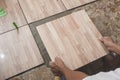 Installing new faux wood printed ceramic tiles. Tile laying and home renovation concept. Royalty Free Stock Photo