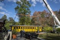 Installing a New Yellow Passenger Antique Coach Being Lifted By a Crane