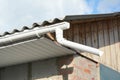 Installing plastic roof gutter with fascias board on old building. Royalty Free Stock Photo