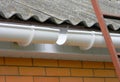 Installing plastic roof gutter pipeline. Unfinished Plastic Guttering, Rain Guttering & Drainage