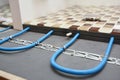 Installing a radiant floor heating system with a close up of heating cables fastened to the floor underlayment under ceramic mosai Royalty Free Stock Photo