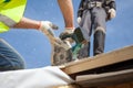 Installing a skylight. Construction Builder Worker use Circular Saw to Cut a Roof Opening for window. Royalty Free Stock Photo