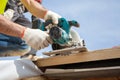 Installing a skylight. Construction Builder Worker use Circular Saw to Cut a Roof Opening for window. Royalty Free Stock Photo