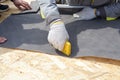 Installing Skylights in new home. Construction mason worker attach insulation material on Oriented Strand Board. Royalty Free Stock Photo