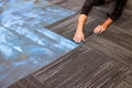 Installing textured carpet tiles in a office space during work day on process materials used Royalty Free Stock Photo