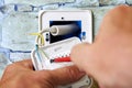 Installing wall thermostat for floor heating system, an electrician secures wire to outlet terminal. Royalty Free Stock Photo