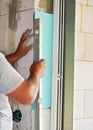 Installing white polystyrene foam board insulation on a bare wall next to window - closeup detail during house Royalty Free Stock Photo