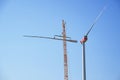 Installing a wind turbine, crane is lifting the second blade to install it to the rotor hub on the tower, heavy industry for