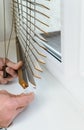 Installing wooden blinds.