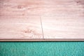 Installing wooden laminate or parquet floor in room over green noise absorbing base, close-up