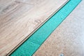 Installing wooden laminate or parquet floor in room over green noise absorbing base, close-up