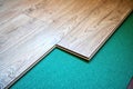 Installing wooden laminate or parquet floor in room over green noise absorbing base, close-up