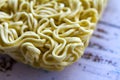 Instant asian yellow noodles on white wooden table.