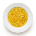 Instant chicken noodle soup in a white ceramic soup plate isolated on white. Top view