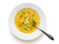 Instant chicken noodle soup in a white ceramic soup plate with metal spoon isolated on white. Top view. Chopped parsley