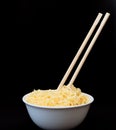 Instant Chinese curly noodles in white bowl with wood sticks on black background. Selective focus. Asian food concept Royalty Free Stock Photo