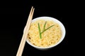 Instant Chinese curly noodles in white bowl with wood sticks on black background. Selective focus. Asian food concept Royalty Free Stock Photo