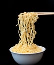 Instant Chinese curly noodles in white bowl with wood sticks on black background. Selective focus. Asian food concept Royalty Free Stock Photo