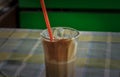 Instant coffe in a glass with a red straw