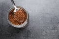 Instant coffee and spoon above glass jar on grey table, top view. Space for text Royalty Free Stock Photo