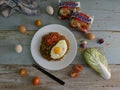 Fried noodles served with fried egg. Food flat lay concept. From top view on wood background