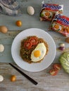 Fried noodles served with fried egg. Food flat lay concept. From top view on wood background