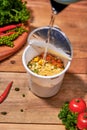 Instant noodle, asian fast food, noodle cup on wooden background