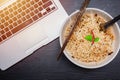 Instant noodle with computer laptop for low cost cheap eat and unhealthy high carbohydrate food concept Royalty Free Stock Photo