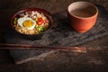 Instant noodle with pork, egg and vegetables on black bowl on the wood table there are chopstick and drinking glass placed around Royalty Free Stock Photo