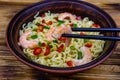 Instant noodle with shrimps, red pepper and green onion in a ceramic bowl. Japanese food. Chopsticks with shrimp Royalty Free Stock Photo