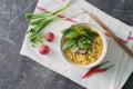 Instant noodles in bowl with radish, herbs and onion