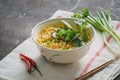 Instant noodles in bowl with radish, herbs and onion