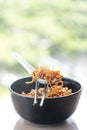 Instant noodles korean hot chili ramen stlye with pork crackink chilli paste in black bowl with chopstick