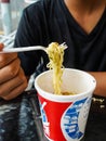 instant noodles, noodle soup in a cup, boys hand feeding ready to eat noodles