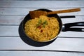 Instant noodles with vagetables, pepper and onion in a frypen, Asian meal on a wooden background