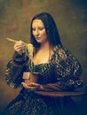 Young woman as Mona Lisa on dark background. Retro style, comparison of eras concept.