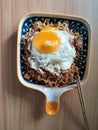 instantly fried noddle with a fried egg with wooden background